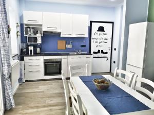 a kitchen with white cabinets and a blue wall at La Casa di Anna in Palmi