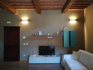 a living room with a couch and a tv at Appartamento il castellare in Rapolano Terme