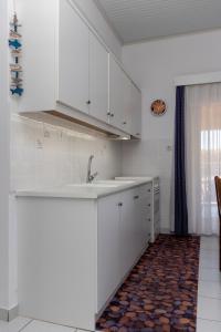 a kitchen with white cabinets and a sink at Fully Equipped Beach House at Pachia Ammos Plytra in Plitra
