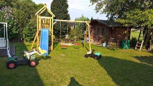 um parque infantil com dois carros de brinquedo e um baloiço em Haus Heimathafen em Süssau