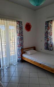 a bedroom with two beds in a room with windows at Fully Equipped Beach House at Pachia Ammos Plytra in Plitra