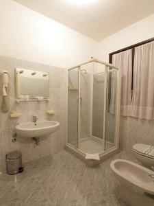 a bathroom with a shower and a sink and a toilet at Hotel Aquavite in Gardone Riviera