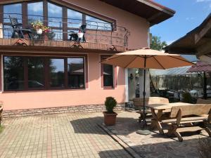 a patio with a table and an umbrella in front of a house at Sea & BBQ apartment , 2nd floor in Liepāja