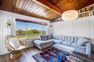 a living room with a blue couch and a window at Cape Meares Beach Getaway in Cape Meares