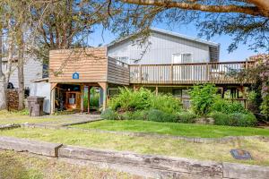 a house with a deck and a yard at Bayocean Retreat in Cape Meares