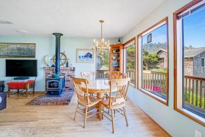 a dining room with a table and chairs and a fireplace at Bayocean Retreat in Cape Meares