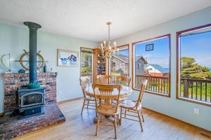 a dining room with a fireplace and a table and chairs at Bayocean Retreat in Cape Meares