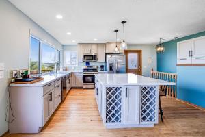 a kitchen with white cabinets and blue walls at Bayocean Retreat in Cape Meares