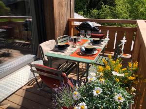 a table on a deck with wine glasses and flowers at Appartements Chalet Le Fornay in Morzine