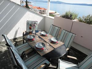a table and chairs on a balcony with a view of the water at Apartman Tina Selce in Selce