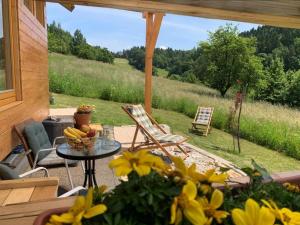 eine Terrasse mit Stühlen und einem Tisch mit Bananen darauf in der Unterkunft Hillside Bio Resort Delux Apartments in Šešče pri Preboldu
