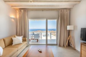 un soggiorno con divano e una grande finestra di Elma’s Summerhouses a Mykonos Città