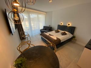 a bedroom with a bed and a table and a couch at ApartPark Apartament Albus in Świnoujście