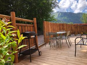 a wooden deck with chairs and a table and a fence at Appartements Chalet Le Fornay in Morzine