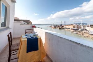 a table on a balcony with a view of the water at Cortile San Giovanni in Mazara del Vallo