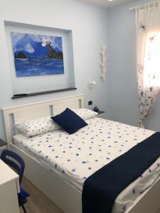 a bedroom with a bed with a painting on the wall at La Casa di Anna in Palmi