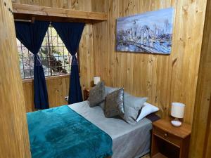 a bedroom with a bed and a painting on the wall at Cabañas Boutique - El Renegado Y Rustica in Recinto