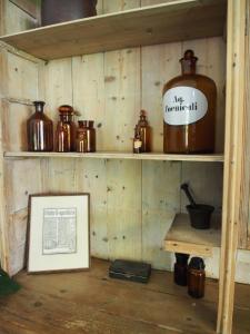 een kamer met houten planken met potten en een foto bij De oude dokterspraktijk in Zuidhorn