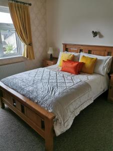 a bedroom with a large bed with four pillows at Noraville House in Killarney