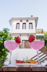 two glasses filled with strawberries and a plate of fruit at Aegean Blue - Villas Stivachtis in Agios Ioannis Pelio
