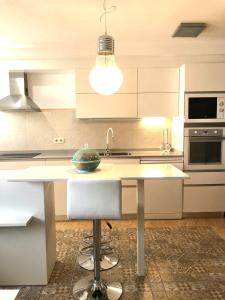 - une cuisine avec un comptoir blanc et un évier dans l'établissement Apartament Riba Riu, à Deltebre