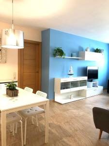 un salon avec une table et un mur bleu dans l'établissement Apartament Riba Riu, à Deltebre