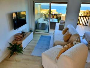 uma sala de estar com dois sofás e uma televisão em Penthouse Haramara, Romana Playa Marbella em Marbella