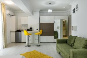 een woonkamer met een groene bank en gele stoelen bij North Club Apartments II in Mamaia