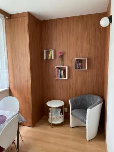 a living room with a chair and a table at Apartment Fialka in Olomouc