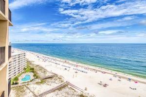 an overhead view of a beach with people and the ocean at The Phoenix V Resort in Orange Beach