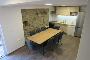 a kitchen with a wooden table and chairs at Holiday Home Ljubičić in Baška
