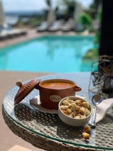 un tazón de comida en una mesa junto a una piscina en Pensiunea Alexandra & SPA, en Divici