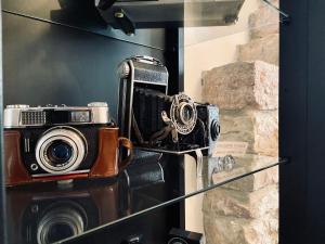 eine Kamera auf einem Glasregal neben einer Kamera in der Unterkunft Quo Vadis in Assisi