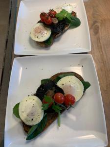 two plates of food with eggs and tomatoes on them at Church Gate Farm in Harrogate