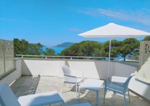 een patio met stoelen, een parasol en een tafel bij Hotel Byron in Lerici