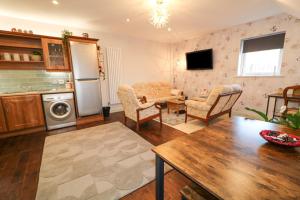 cocina y sala de estar con mesa y sillas en Red Robin's Annex, en Craigavon