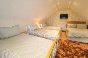 Zimmer im Dachgeschoss mit 2 Betten und einem Sofa in der Unterkunft Red Robin's Annex in Craigavon