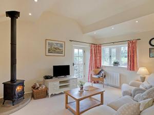 a living room with a couch and a stove at Reynard Ing Cottage in Addingham