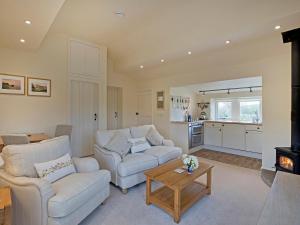 a living room with two couches and a table at Reynard Ing Cottage in Addingham