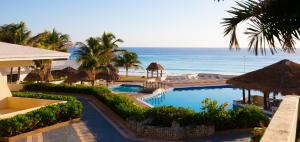 a view of a resort with a swimming pool and the ocean at Brisas Beachfront Penthouses in Cancún
