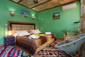 a bedroom with a large bed with green walls at Toubkal Garden in Imlil