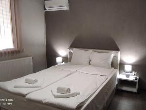 a bedroom with a large white bed with towels on it at BeLApartment in Petrich