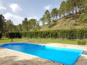 een blauw zwembad voor een heuvel bij Chalet de Montaña Parque Natural Calar Río Mundo - Independiente - Wifi in Riópar