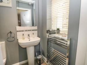 a bathroom with a sink and a mirror at Cartwheel Cottage in York