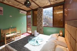 1 dormitorio con 1 cama en una habitación con ventanas en Toubkal Garden, en Imlil