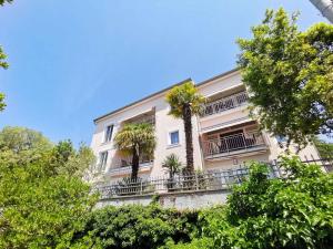 a building with two palm trees on a balcony at Apartment in Crikvenica 5739 in Dramalj