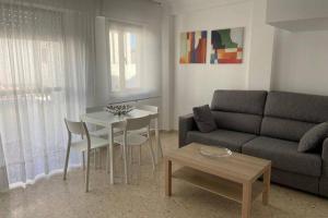 sala de estar con sofá y mesa en Vivienda adosada a 150m de la playa + patio + wifi, en Tarifa