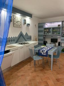 uma cozinha com mesa e cadeiras e uma cozinha com fogão em Appartamento Martina em Codaruina