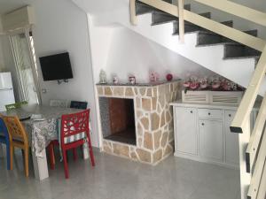 - un salon avec une cheminée en pierre et une table dans l'établissement Villino due palme, à Palumbo