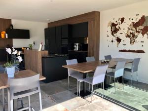 a kitchen and dining room with a wooden table and chairs at HÔTELYA - Lille Villeneuve d'Ascq in Villeneuve d'Ascq